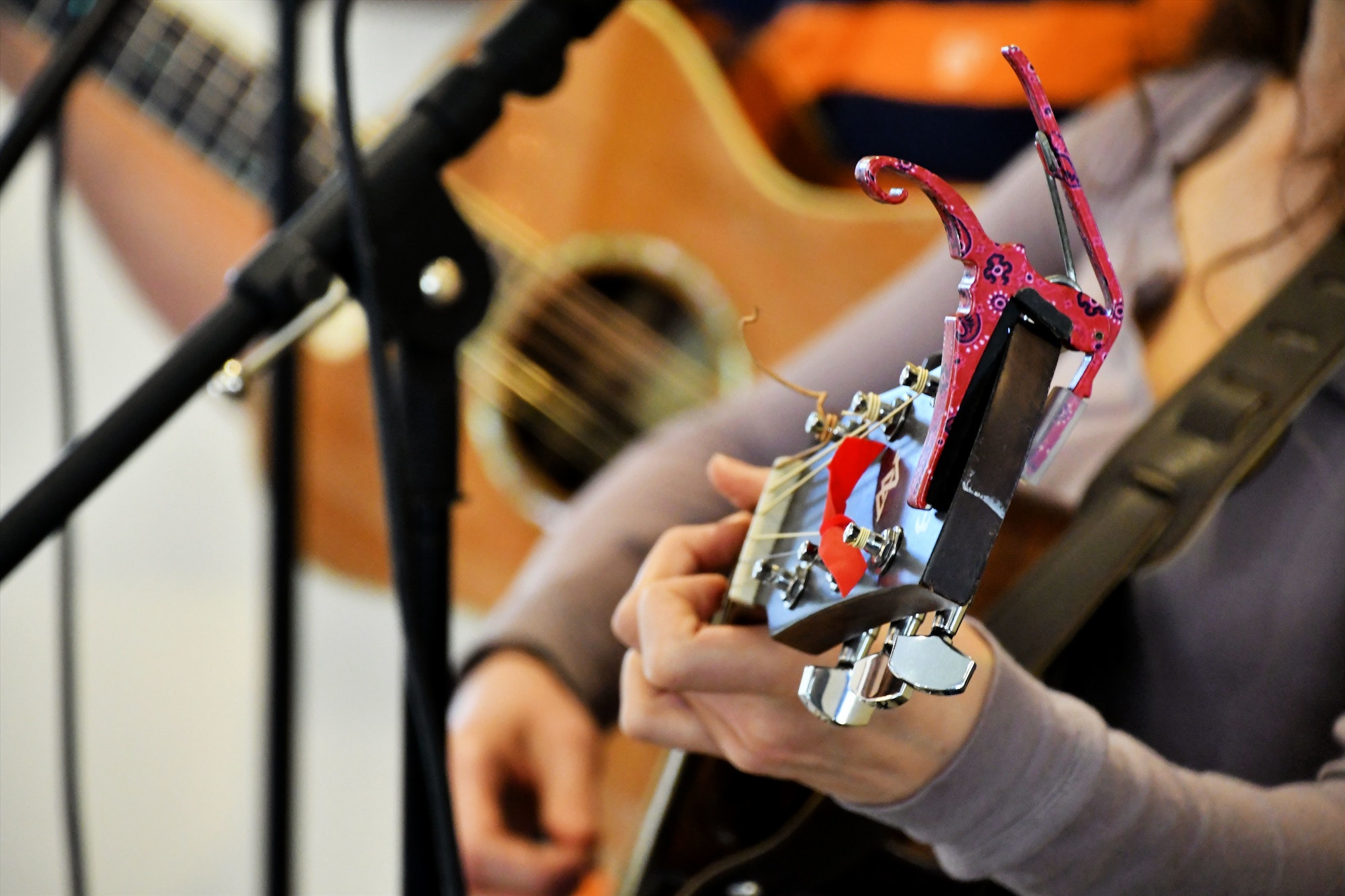 Live music at a festival - Female Playing her guitar while singing. Performing music live on stage.